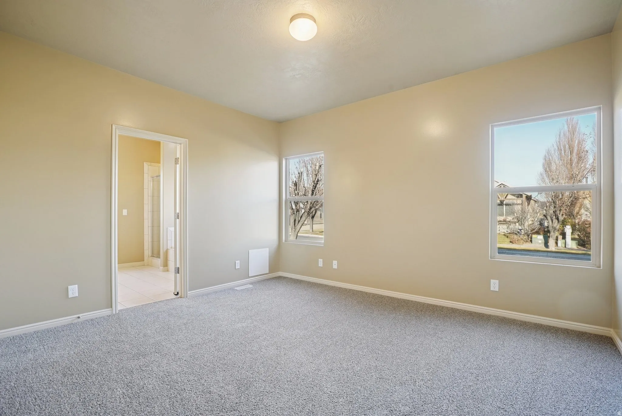 Spare room with light colored carpet and baseboards