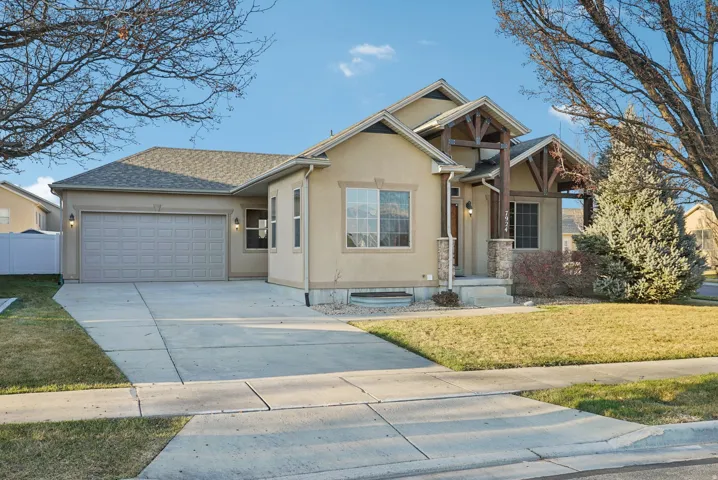 View of front of property featuring stucco siding, a front yard, concrete driveway, an attached garage, and a shingled roof