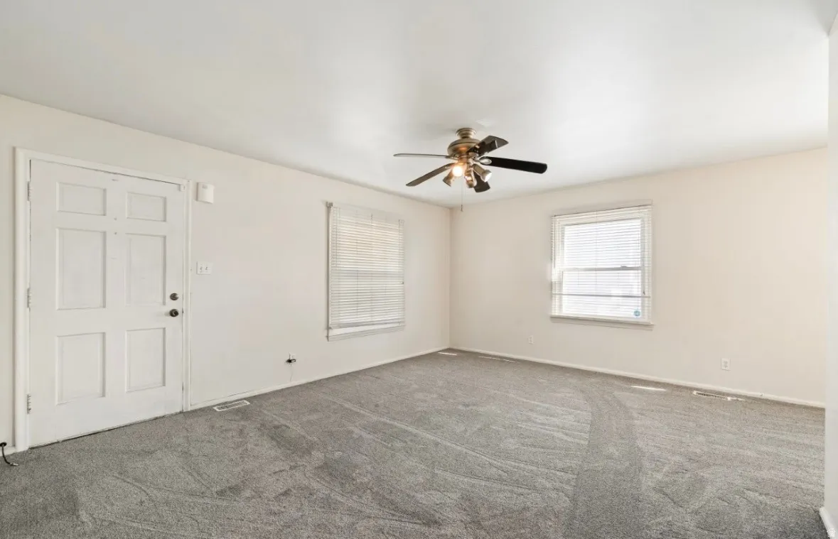 Spare room featuring carpet and a ceiling fan