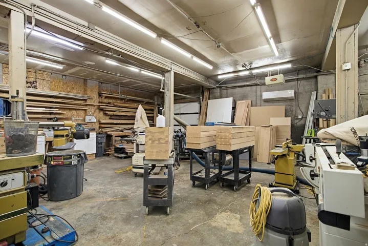 Garage with a workshop area and a wall mounted air conditioner