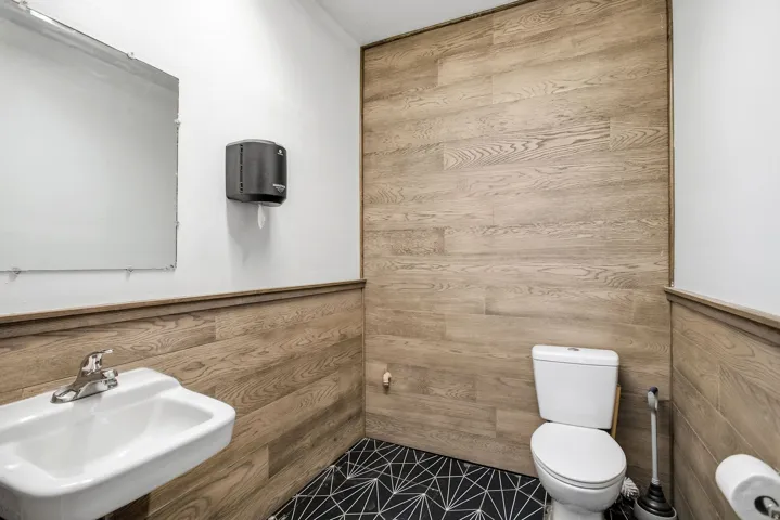 Bathroom with wood walls and a wainscoted wall