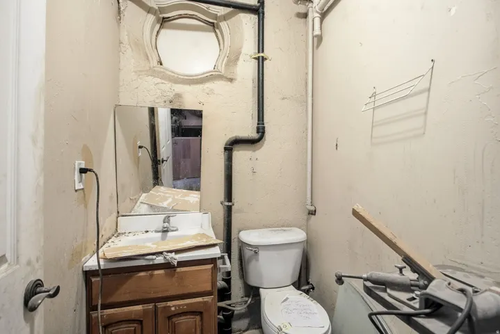 Half bathroom with vanity and a textured wall