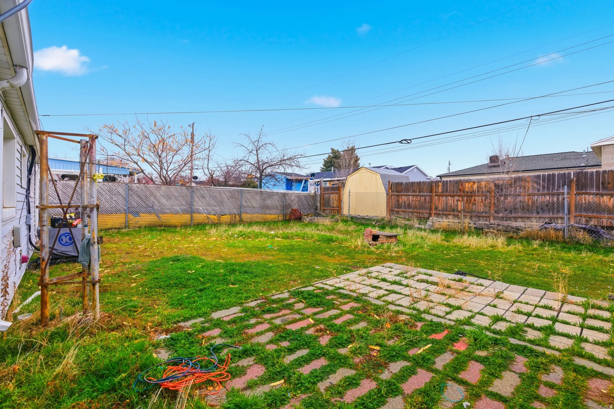 Fenced backyard with a storage shed and a patio