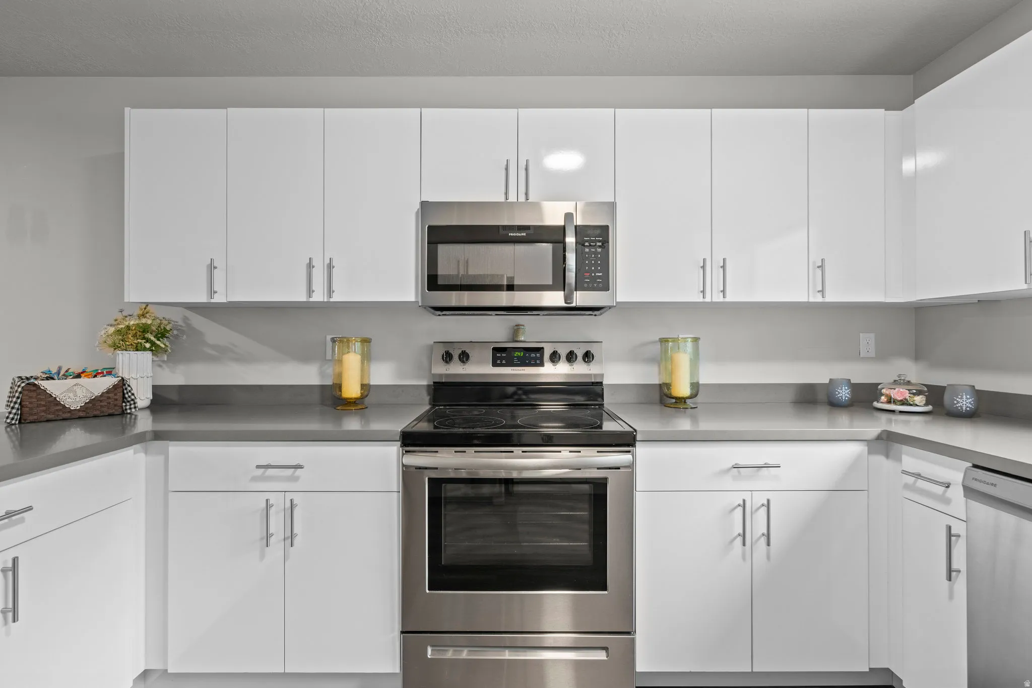 Kitchen featuring appliances with stainless steel finishes and white cabinets