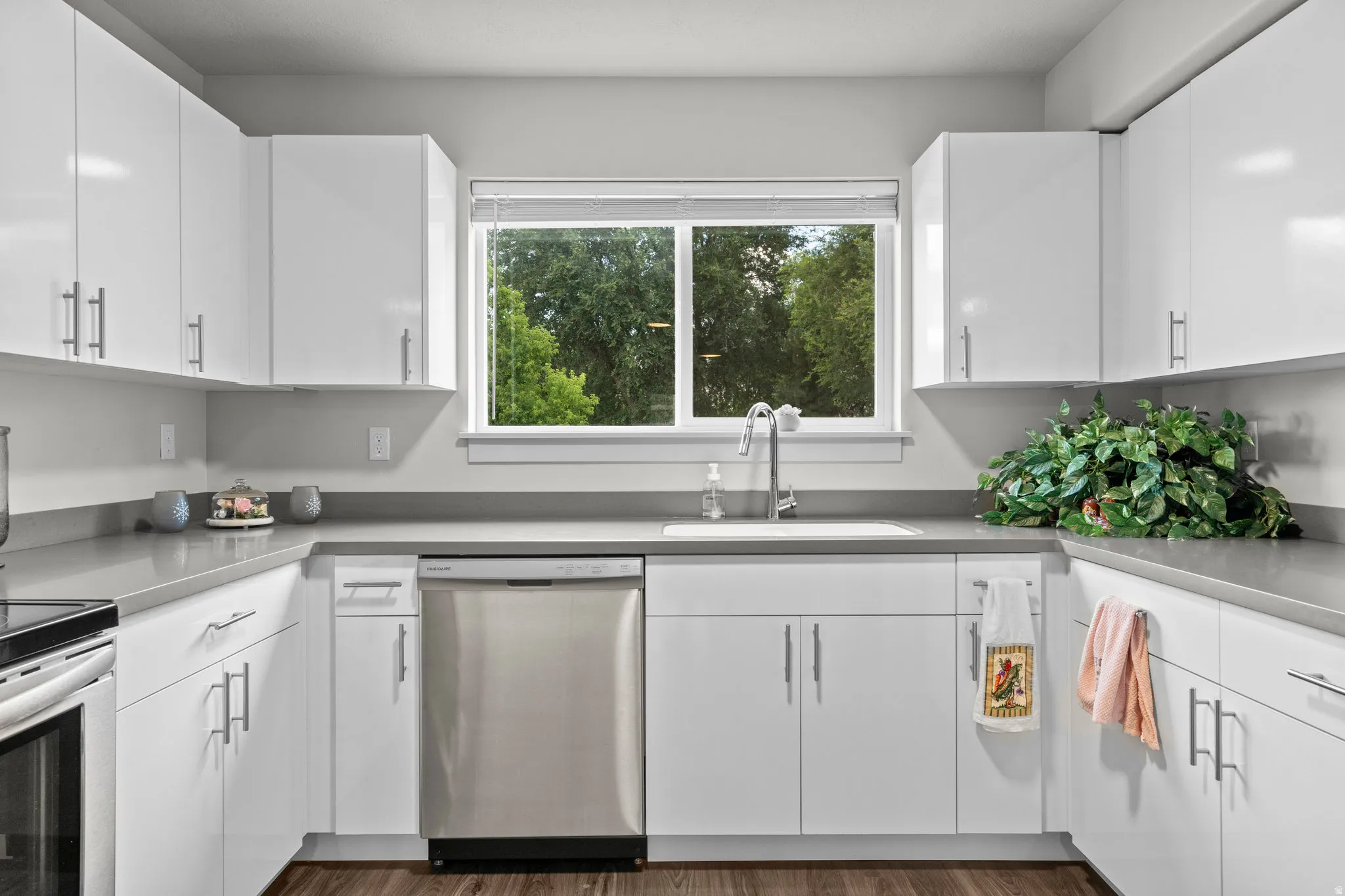 Kitchen featuring appliances with stainless steel finishes, white cabinets, and dark wood-style flooring