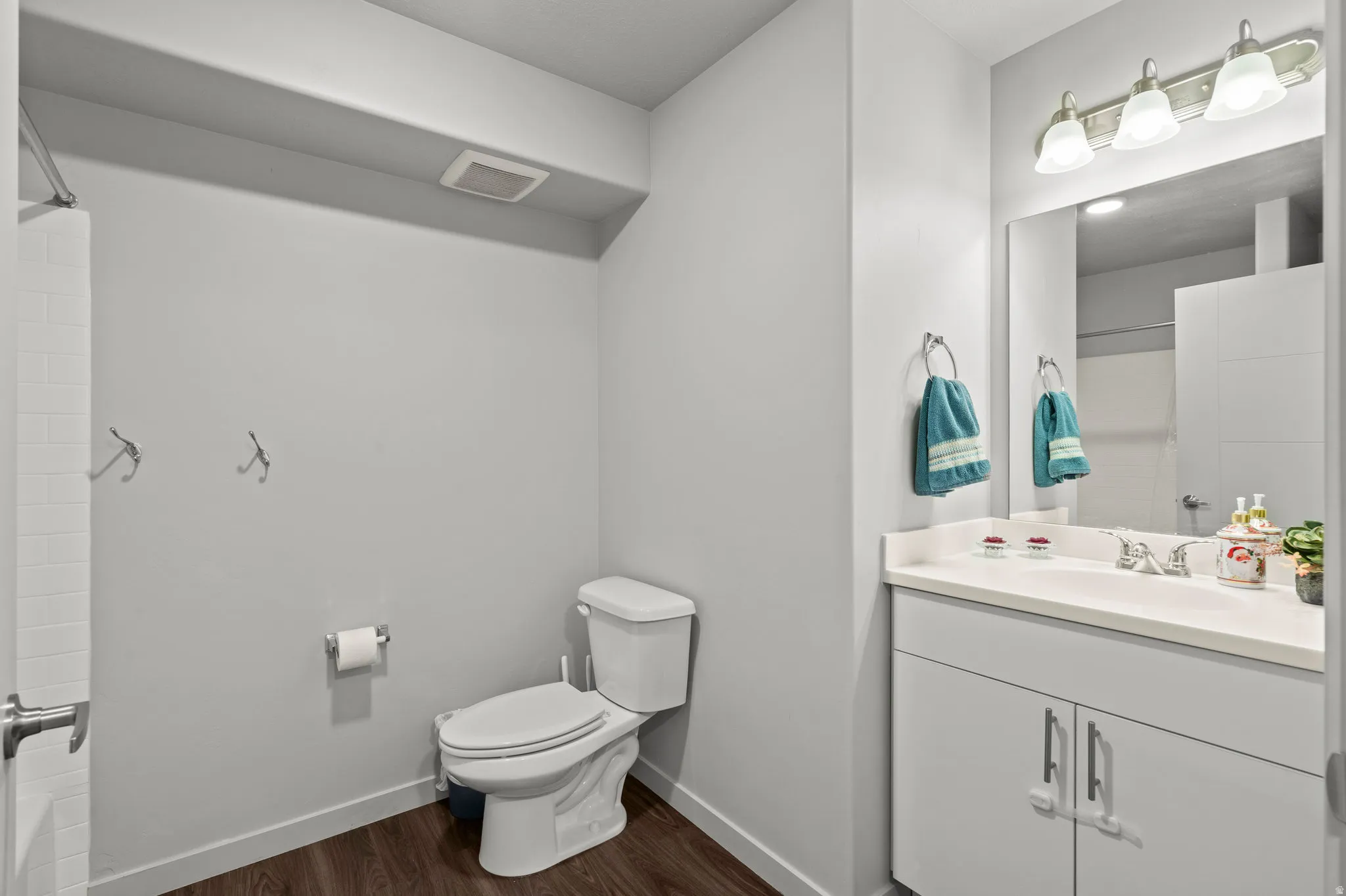 Bathroom with a shower, vanity, and dark wood-type flooring