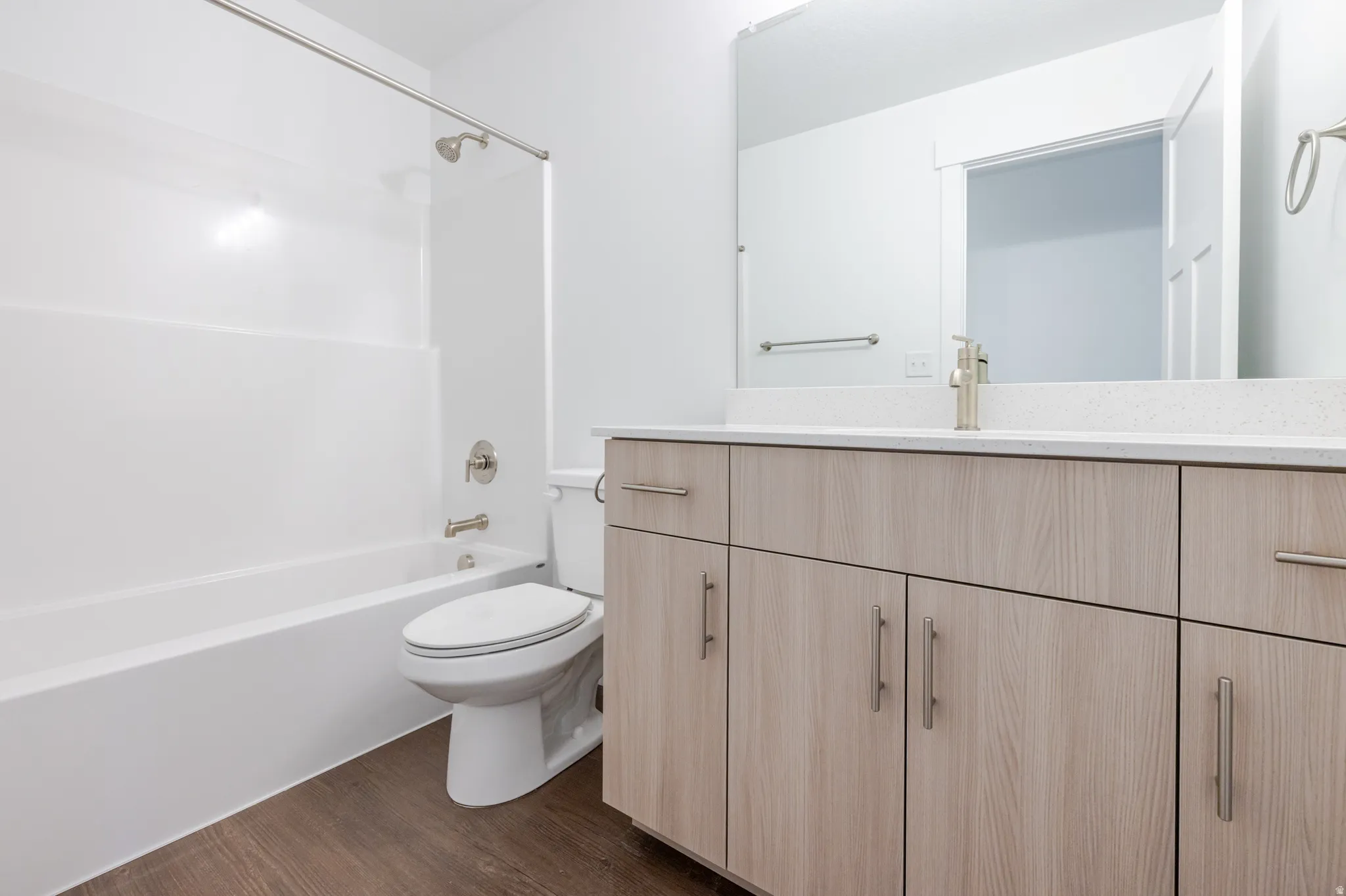 Bathroom featuring a spacious light wood-finish vanity with ample storage, a white countertop, and an integrated sink