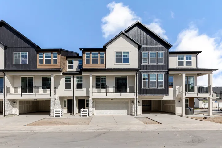 View of front of house featuring concrete driveway, an attached garage, a residential view, and stucco siding