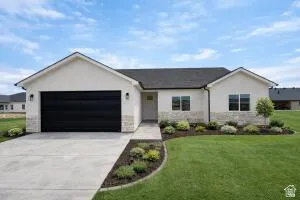 Ranch-style house featuring concrete driveway, stucco siding, a front lawn, and a garage