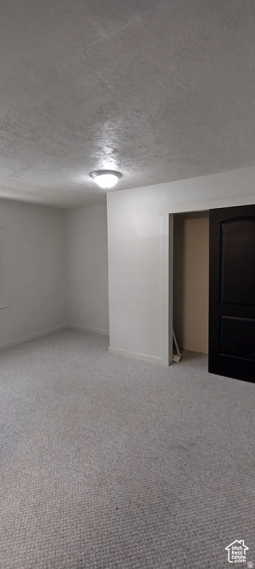 Bedroom featuring a textured ceiling and light colored carpet