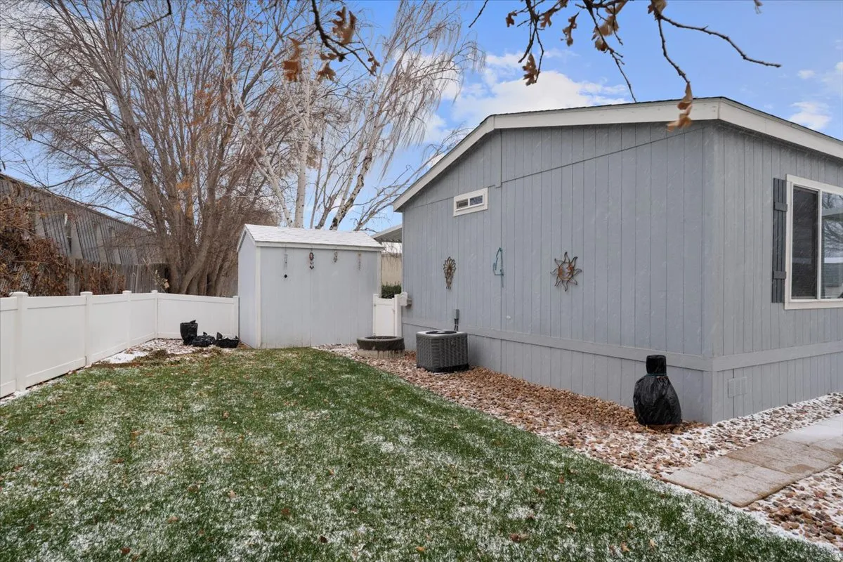 View of property exterior with a fenced backyard and a storage shed