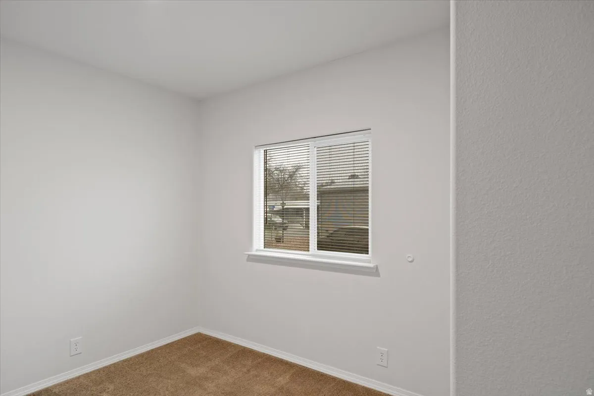 Carpeted spare room with baseboards
