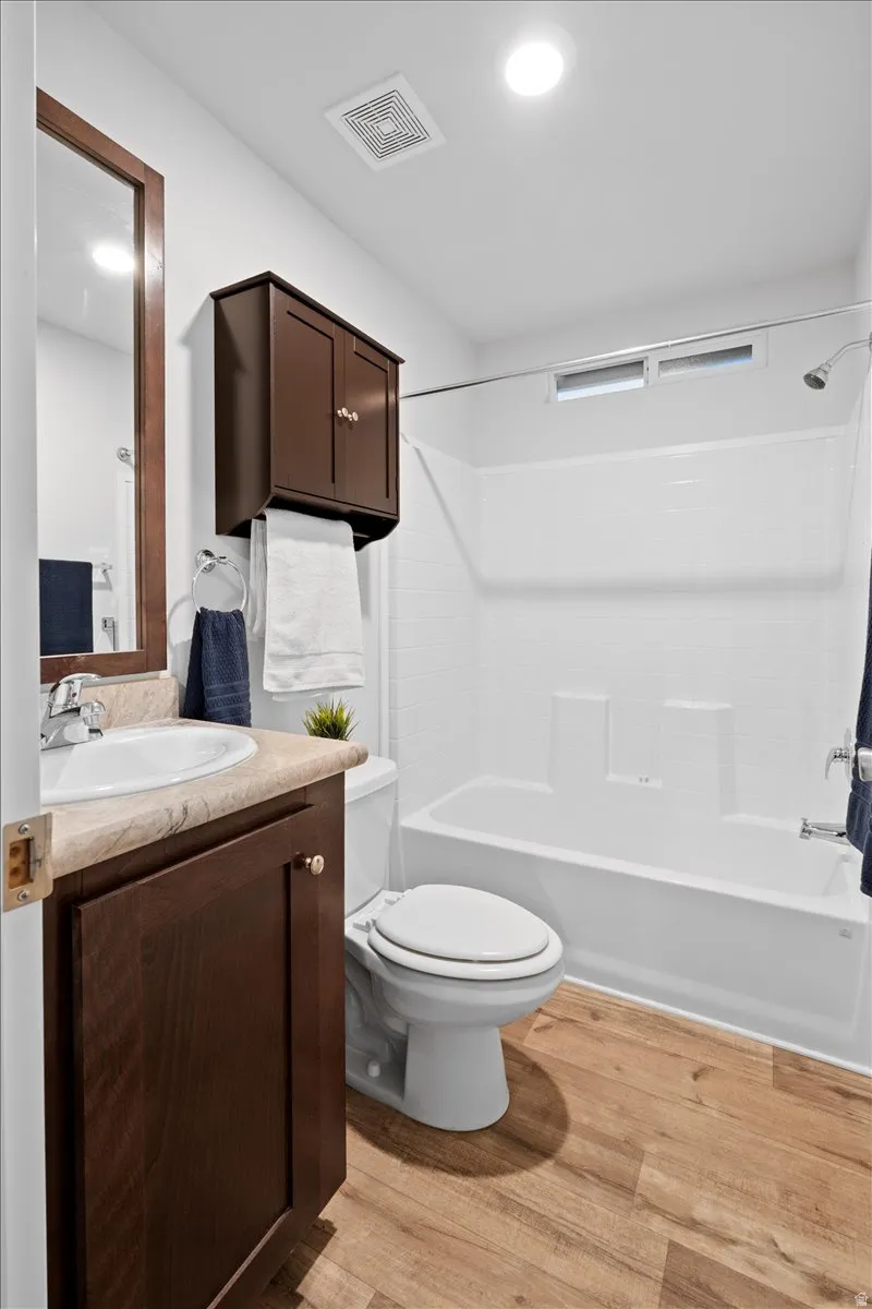 Full bathroom with shower / bath combination, vanity, and light wood-type flooring