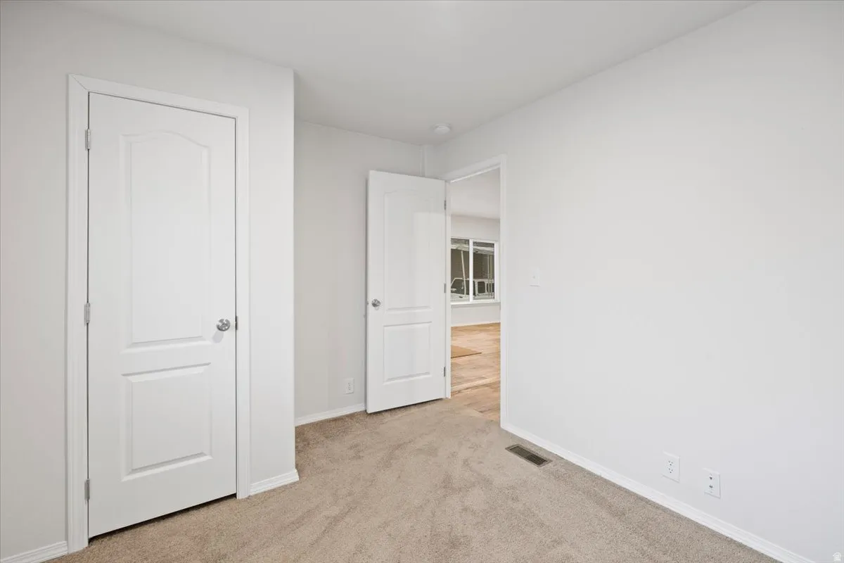 Bedroom with light carpet and baseboards