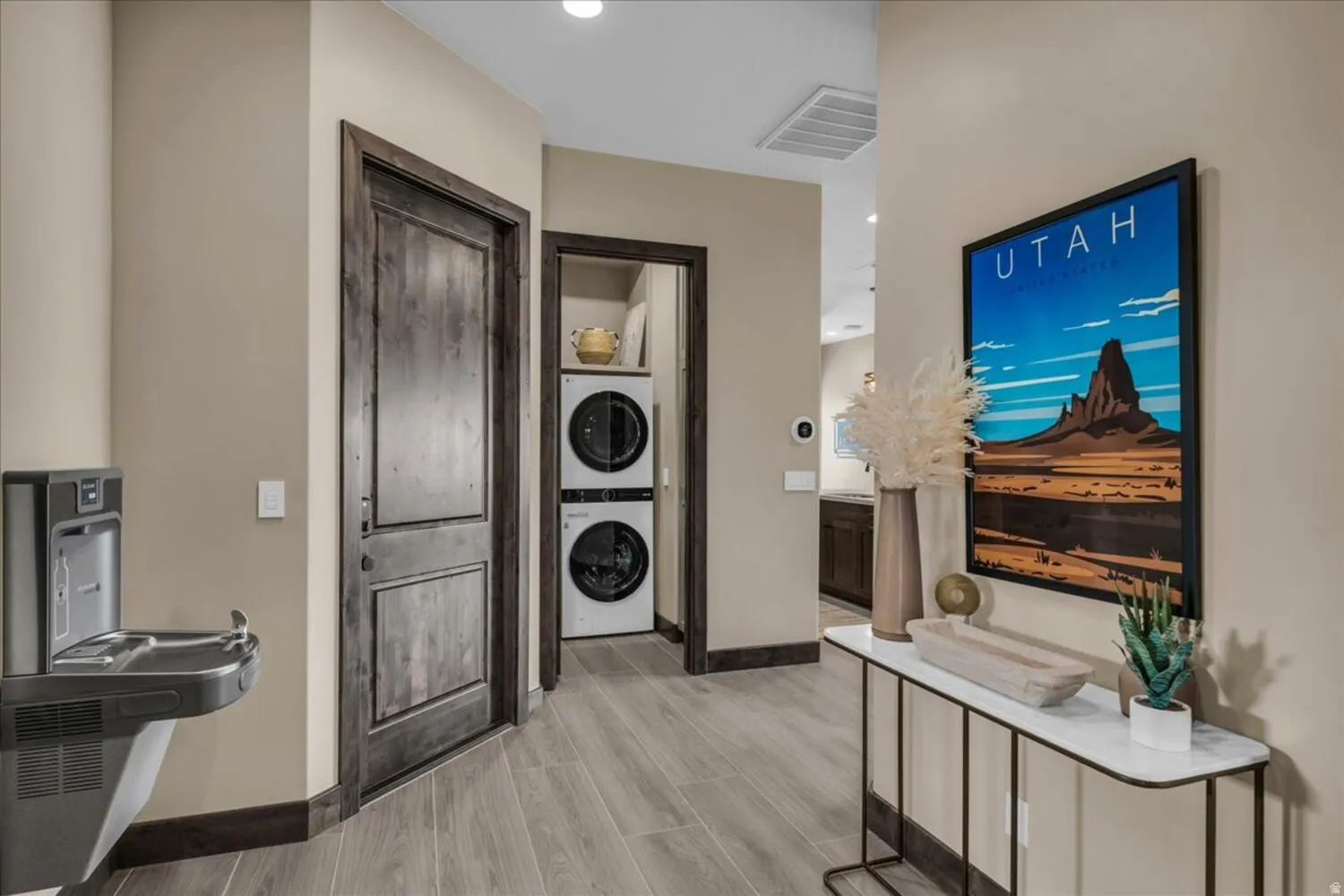 Entrance foyer featuring stacked washing machine and dryer, wood finish floors, and recessed lighting