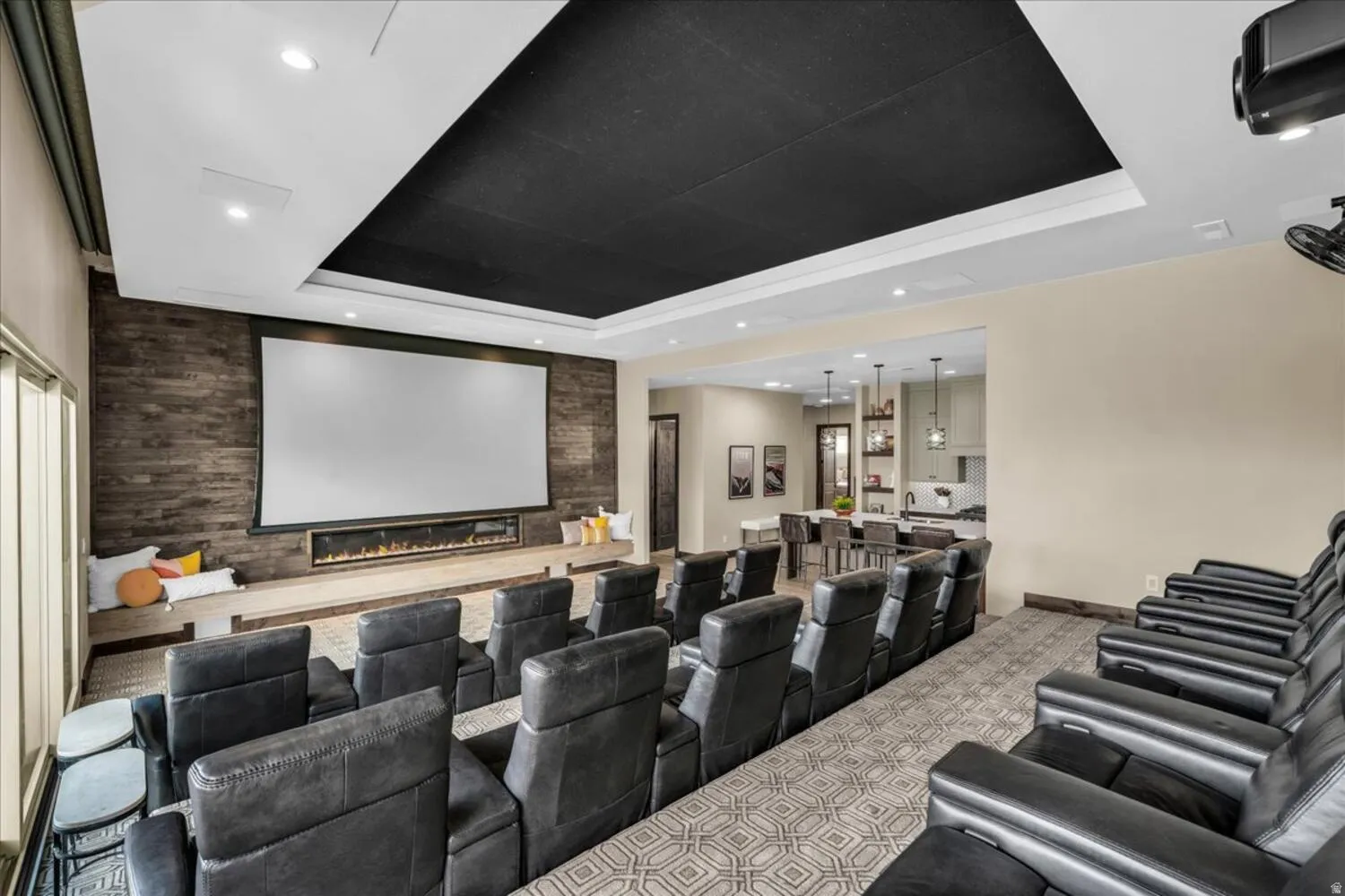Cinema room featuring an accent wall, a tray ceiling, a fireplace, recessed lighting, and light colored carpet