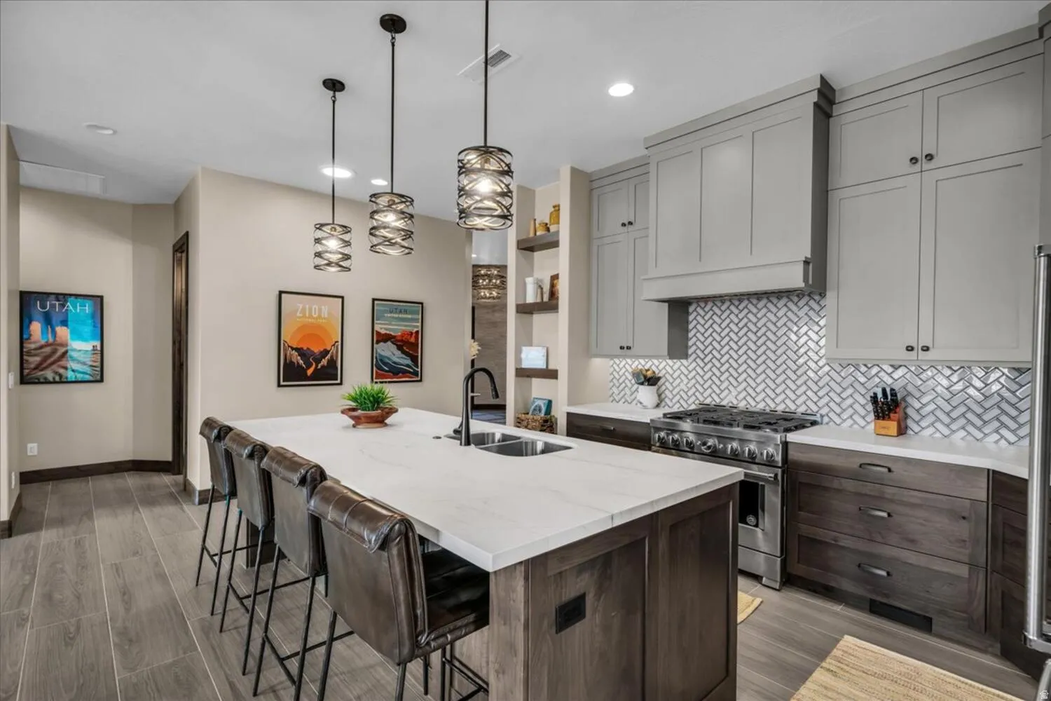 Kitchen with stainless steel stove, backsplash, an island with sink, pendant lighting, and open shelves