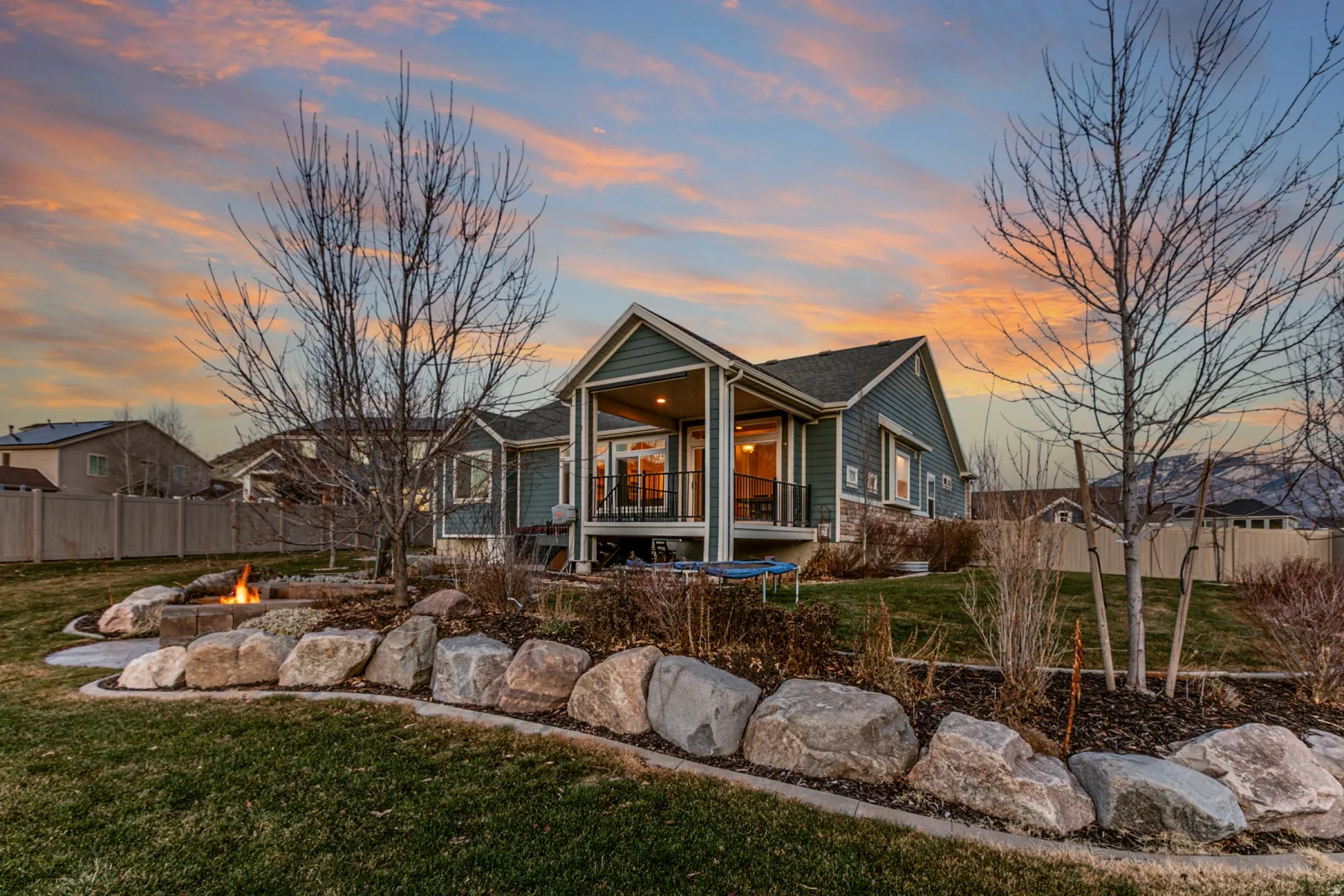 Back of property at dusk with a fire pit