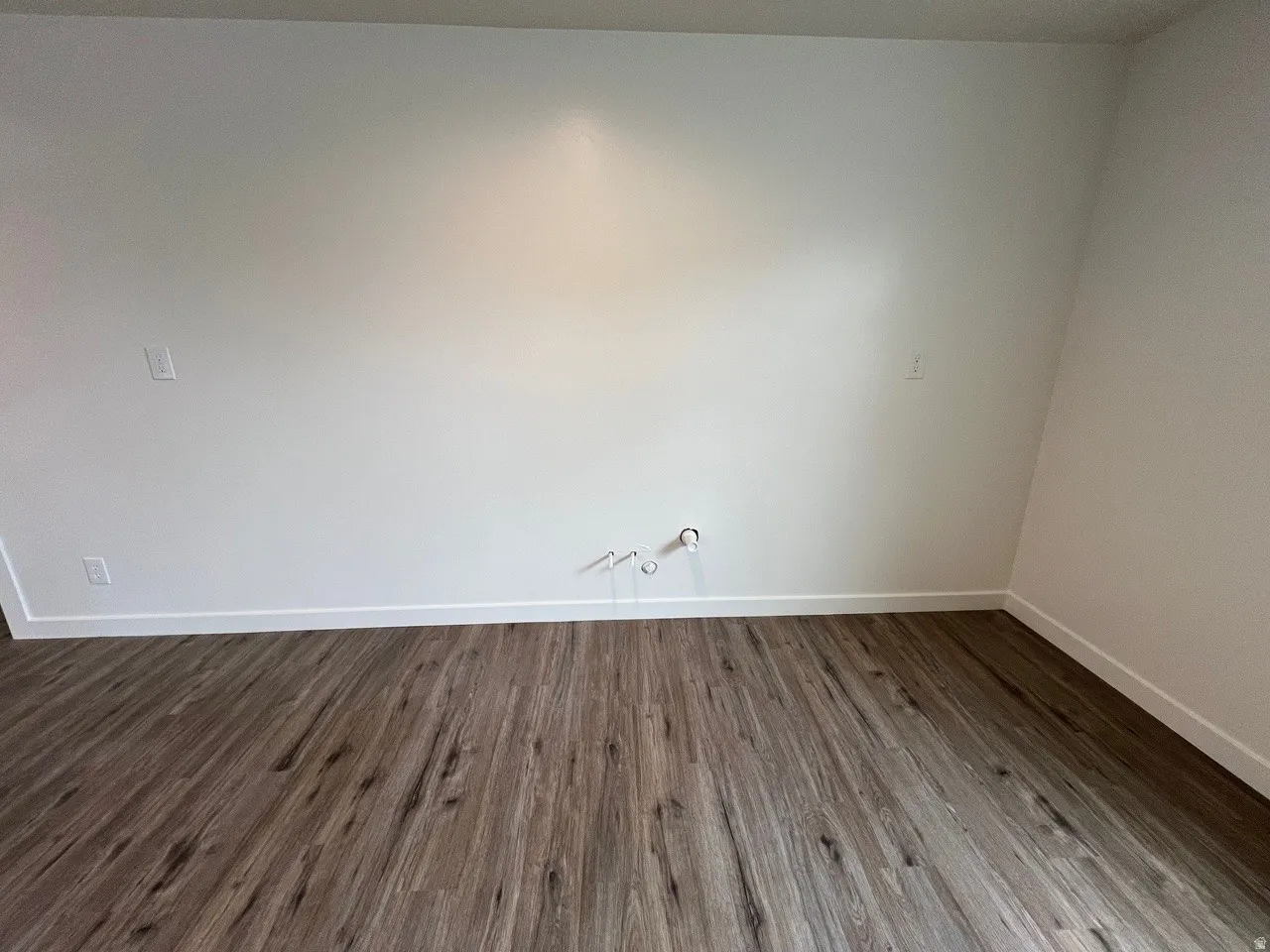 Spare room with dark wood finished floors and baseboards