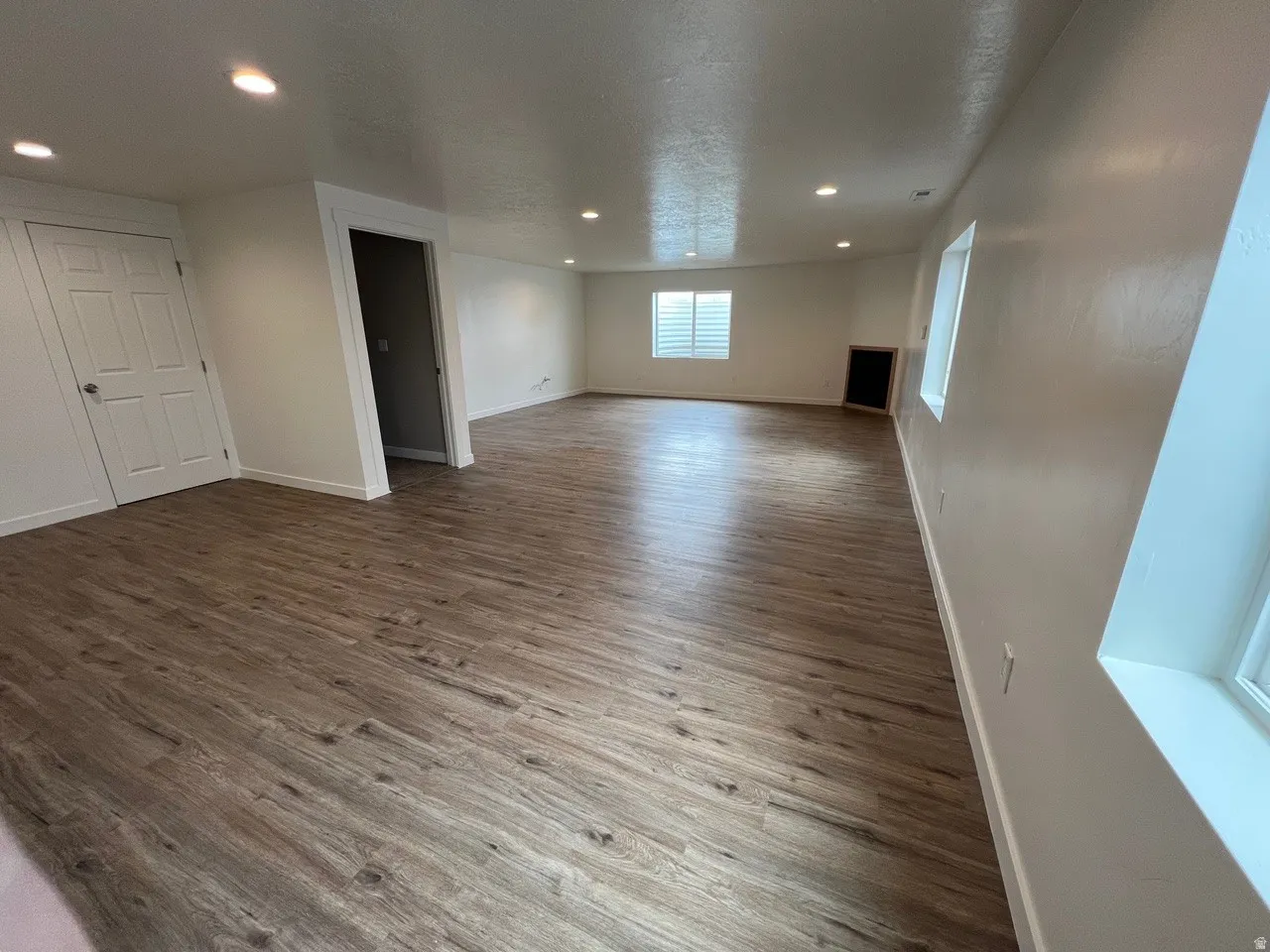 Unfurnished living room featuring wood finished floors, recessed lighting, and a textured ceiling