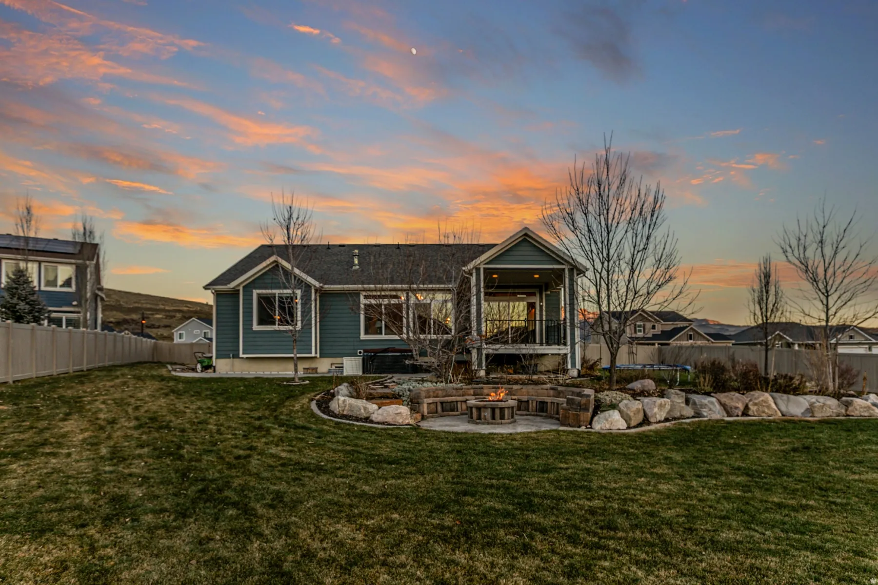 Rear view of property with a fenced backyard, an outdoor fire pit, and a patio area