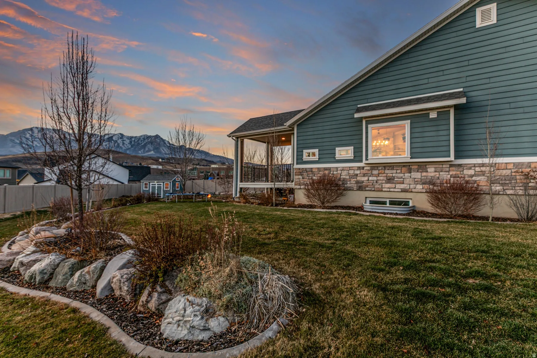 View of home's exterior featuring stone siding, a sunroom, and a mountain view