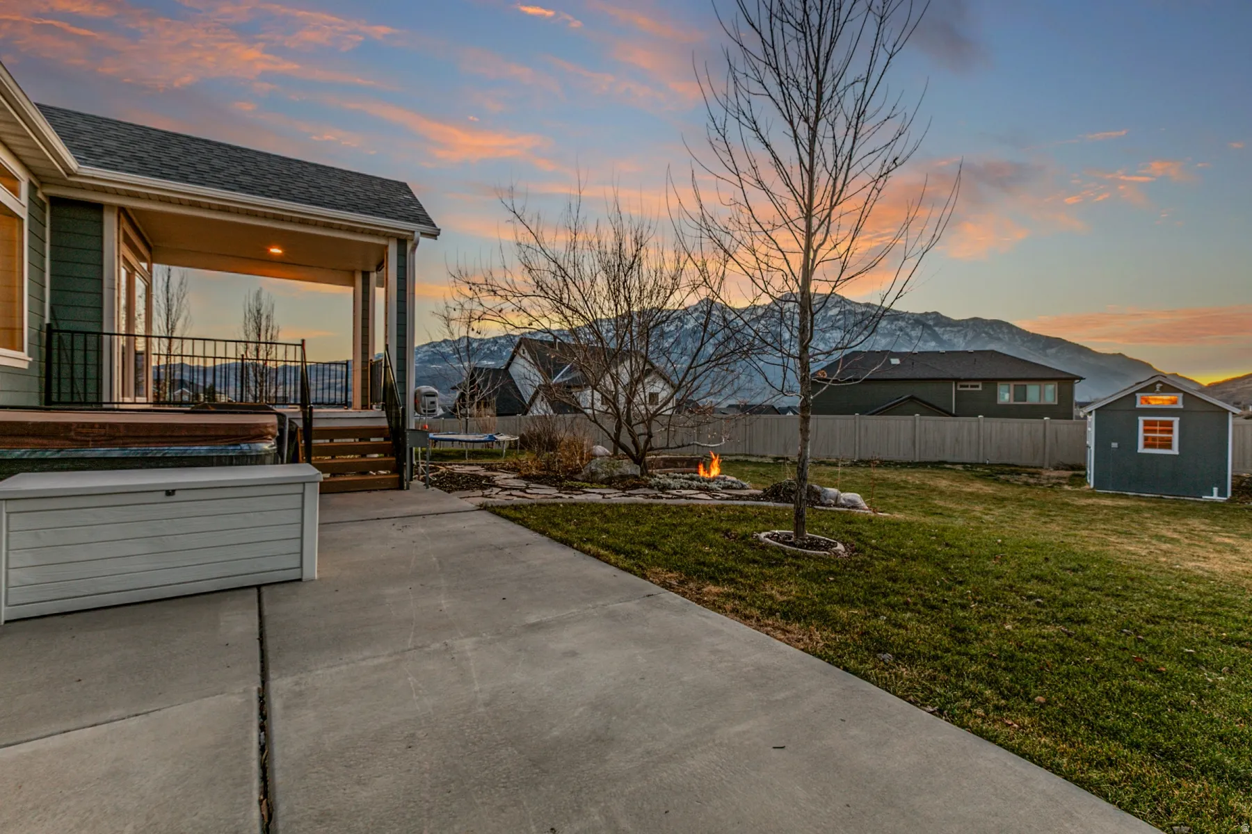 Porch featuring a fire pit, a storage shed, a fenced backyard, a trampoline, and a patio