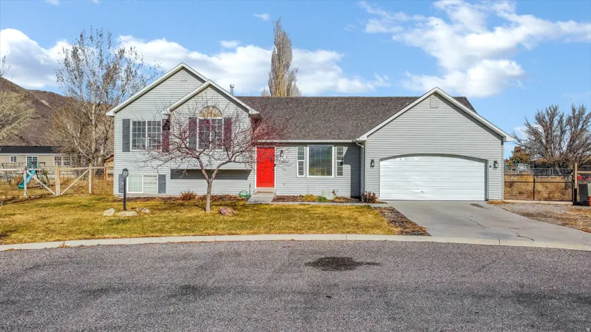 View of front of property featuring driveway, a garage, and a shingled roof.