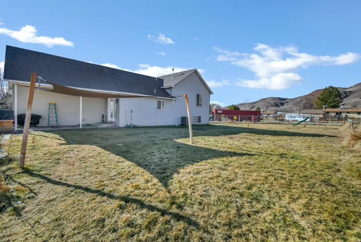 Rear view of property featuring a patio area, a playground, a mountain view, and roof with shingles