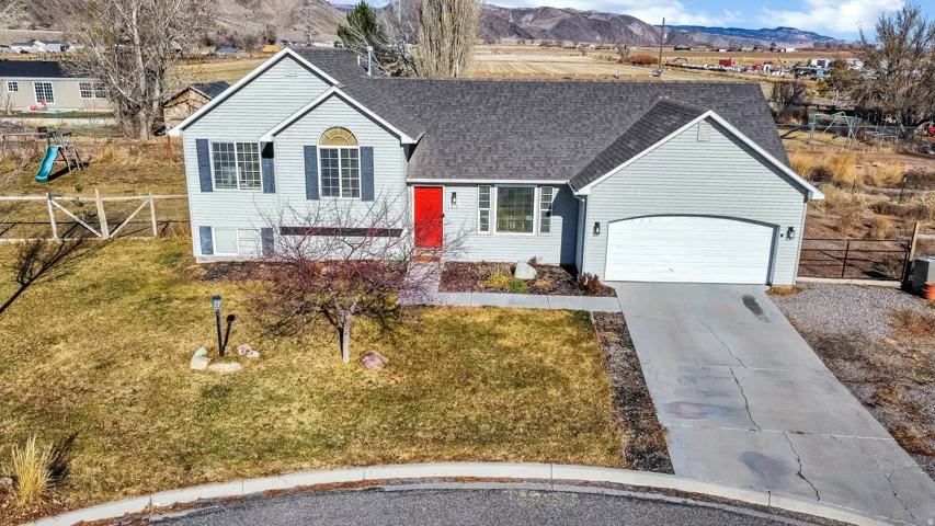 View of front facade with a shingled roof, concrete driveway, a mountain view, and a garage