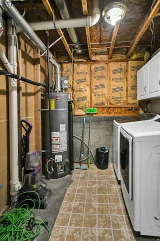 Laundry room with water heater and washing machine and dryer