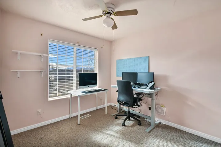 Office space with carpet floors and ceiling fan