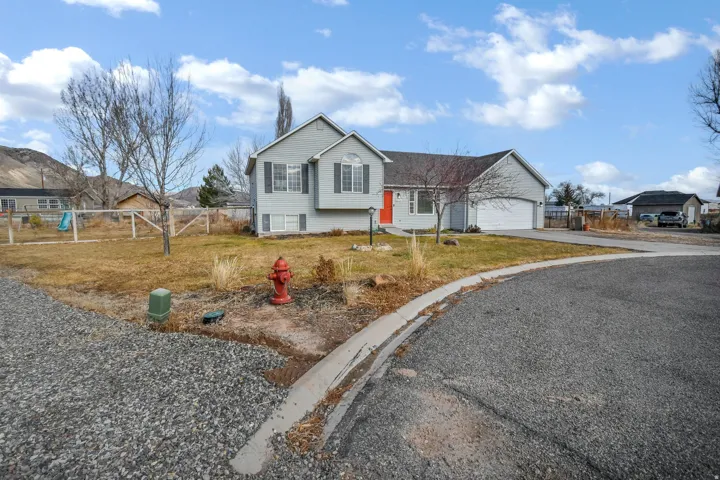 Tri-level home with driveway, a residential view, and a garage.