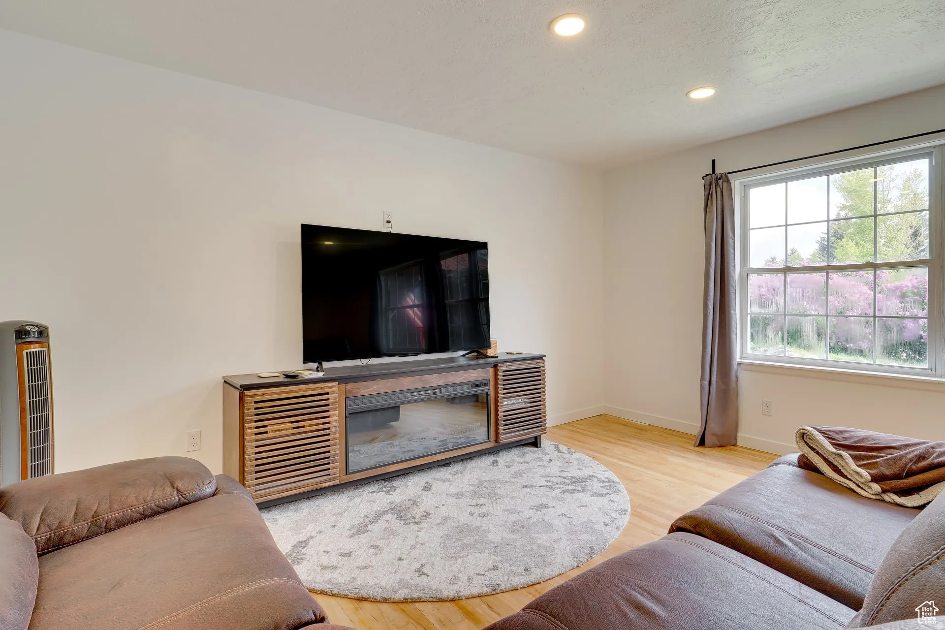 Living area with light wood-type flooring, recessed lighting, and a textured ceiling