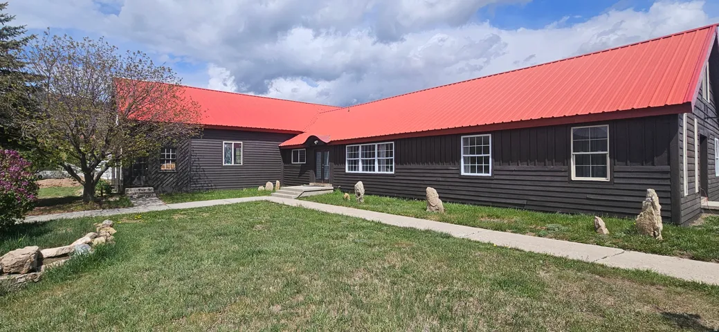 View of front of house with a metal roof and a front yard