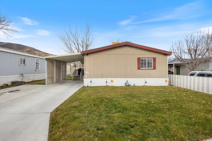Manufactured / mobile home featuring driveway and an attached carport