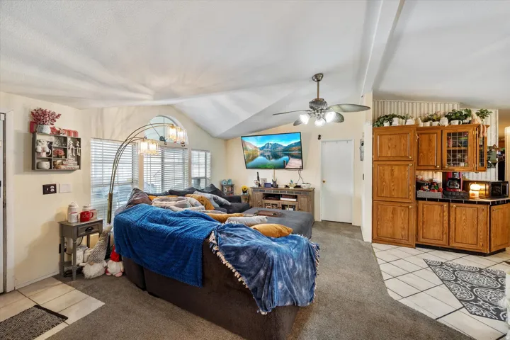 Bedroom with light tile patterned flooring, a chandelier, and a ceiling fan