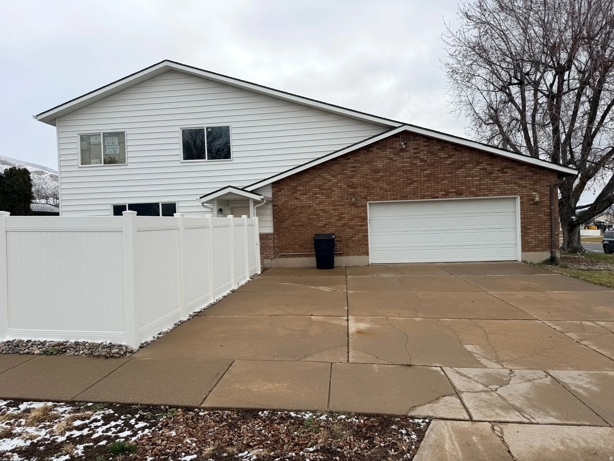 View of property exterior featuring brick siding, concrete driveway, and an attached garage