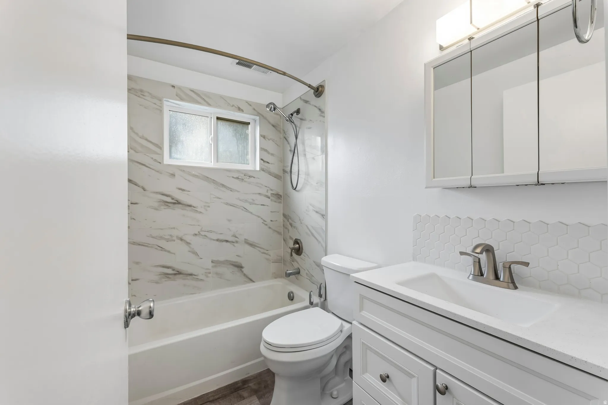 Full bath with vanity, shower / tub combination, and tasteful backsplash