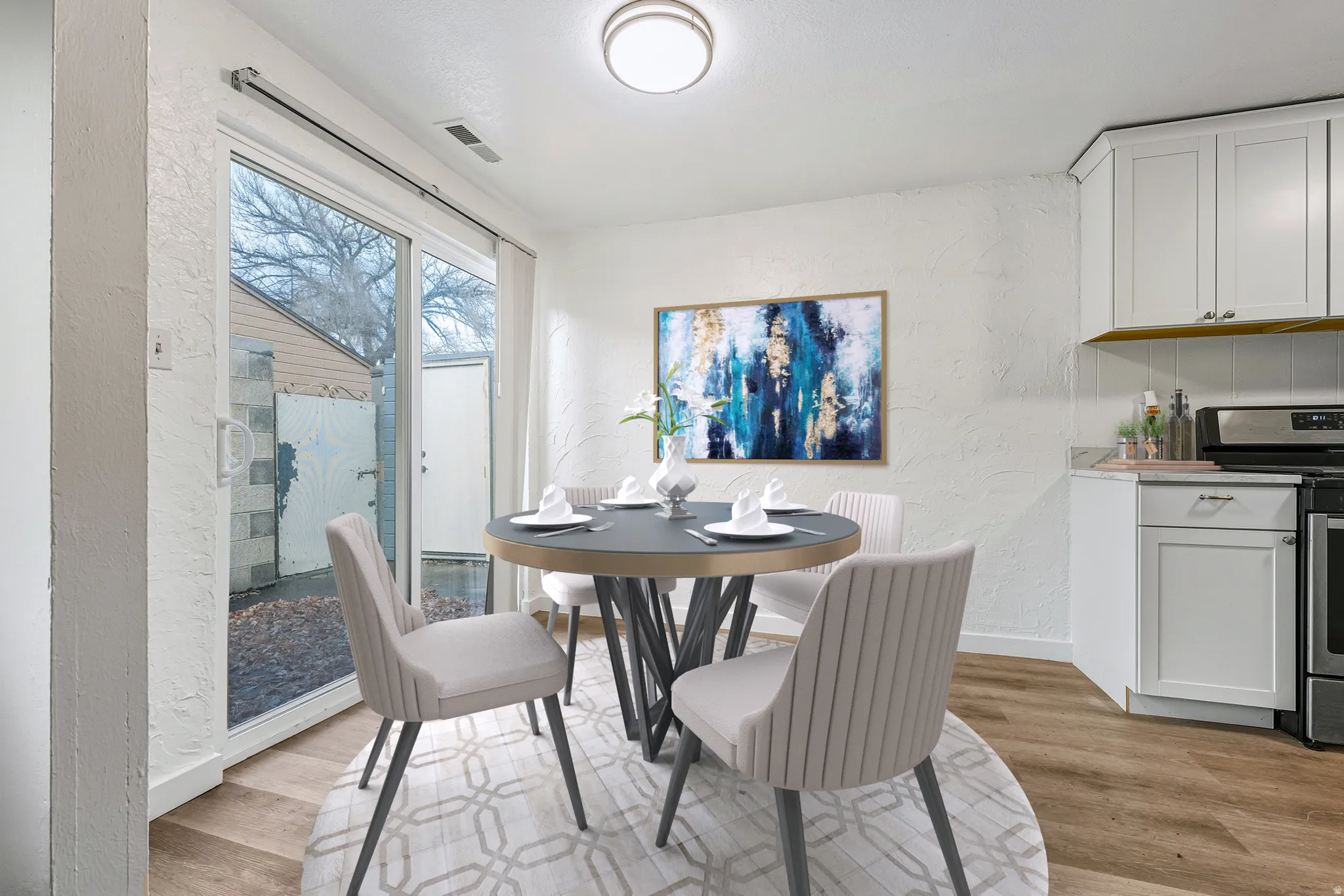 Dining room with a textured wall and light wood-style floors