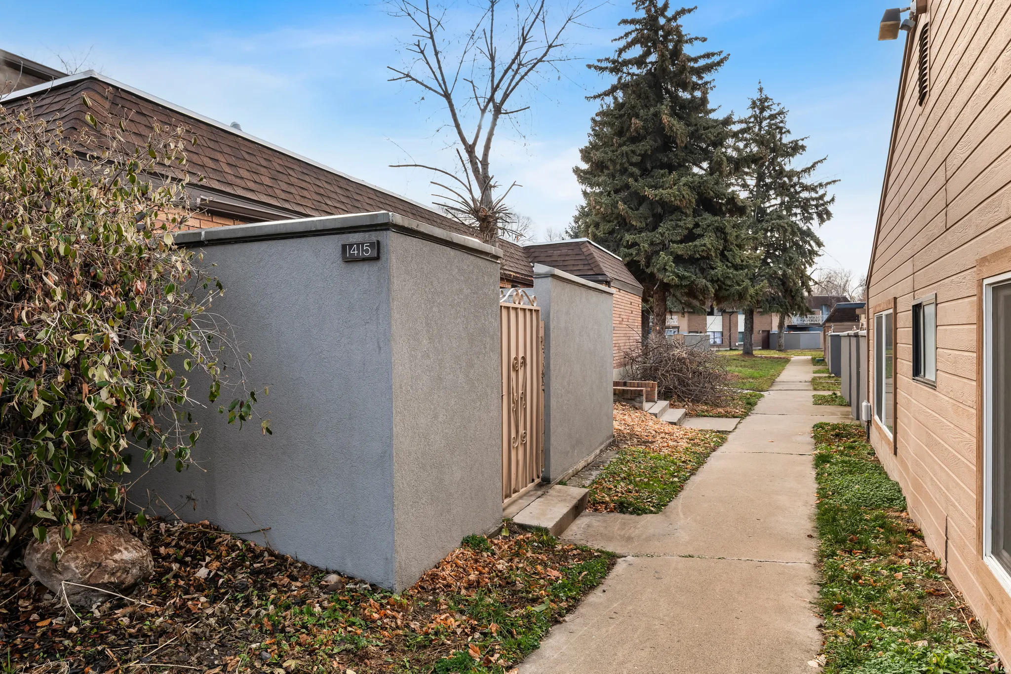 View of property exterior featuring stucco siding and a gate