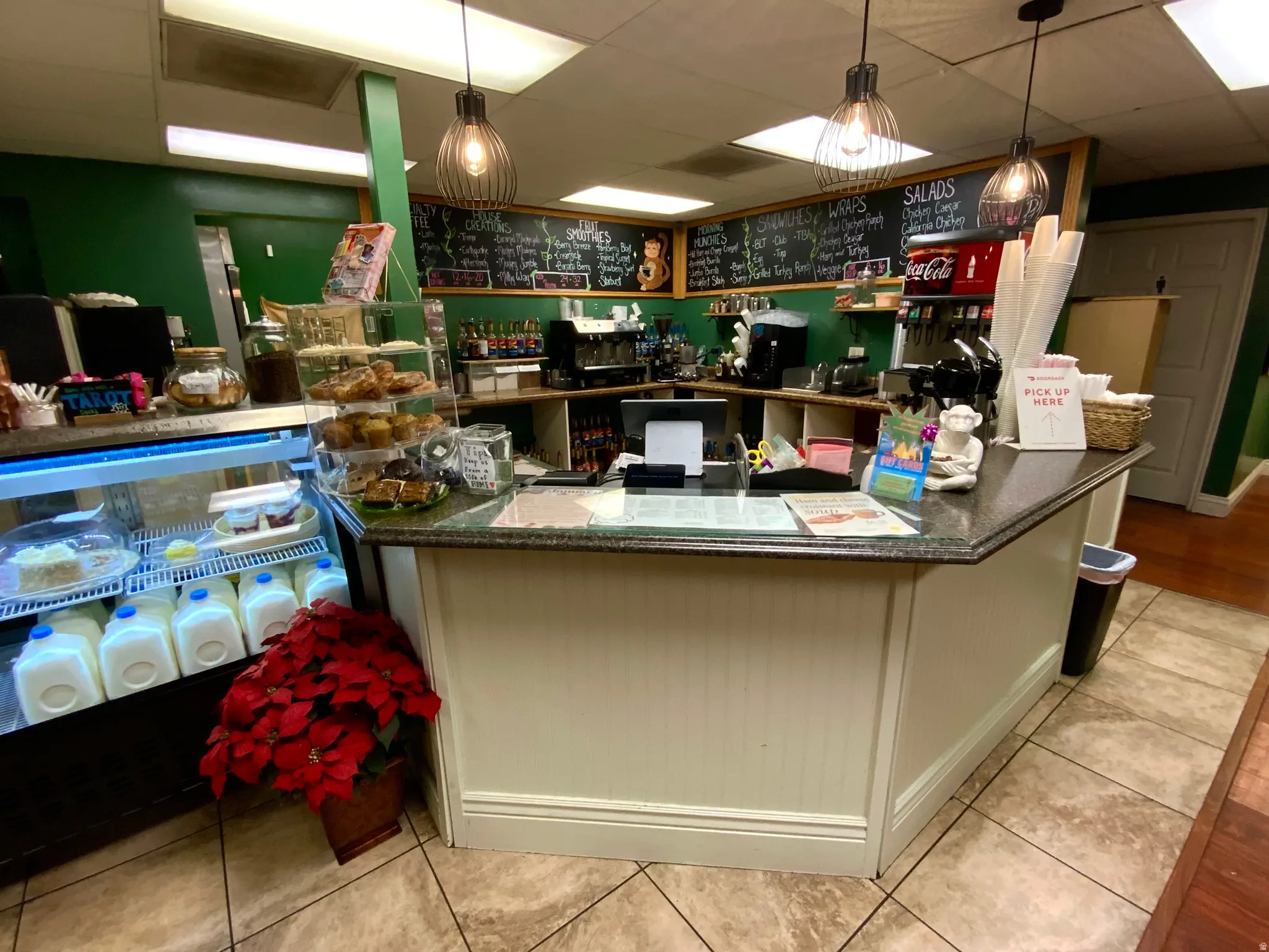 Kitchen with a paneled ceiling, white cabinets, and hanging light fixtures