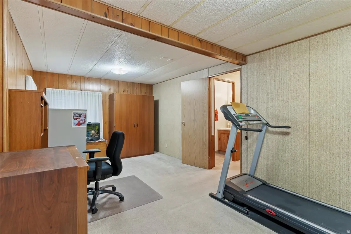 Office area with light colored carpet and wood walls