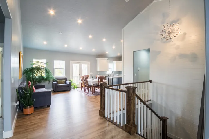 Hallway featuring an upstairs landing, lofted ceiling, light wood-type flooring, recessed lighting, and a chandelier