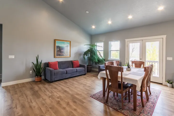 Dining space with light wood-style flooring, high vaulted ceiling, recessed lighting, and french doors