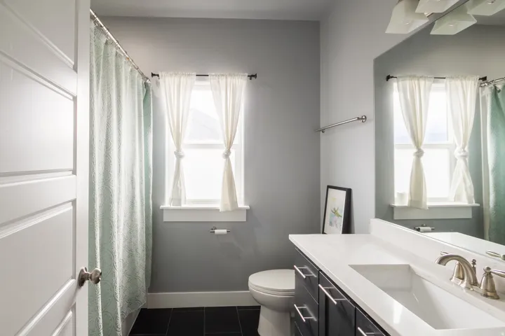 Bathroom featuring vanity, dark tile patterned flooring, and a shower with curtain