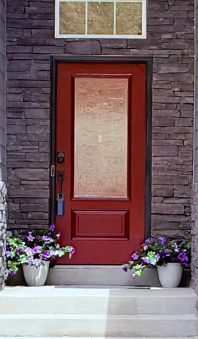 Red entry door with frosted glass panel and decorative trim