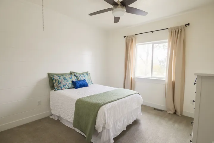 Carpeted bedroom featuring baseboards and ceiling fan