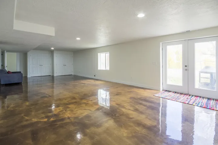 Unfurnished living room featuring french doors, a textured ceiling, recessed lighting, and concrete flooring