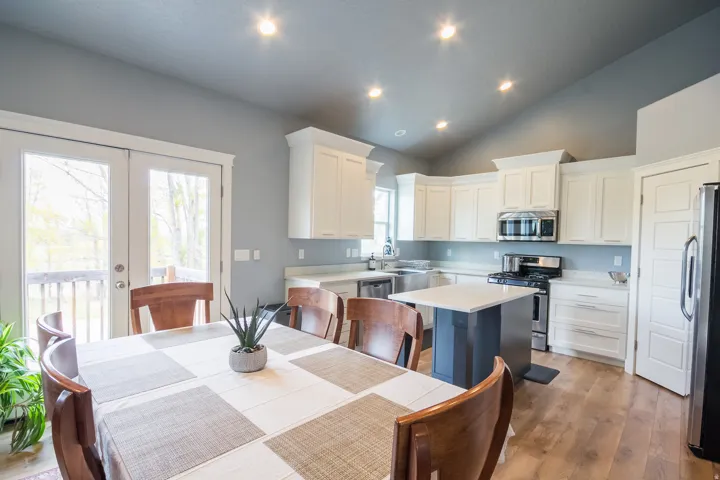 Kitchen with appliances with stainless steel finishes, white cabinets, a kitchen island, recessed lighting, and light wood finished floors